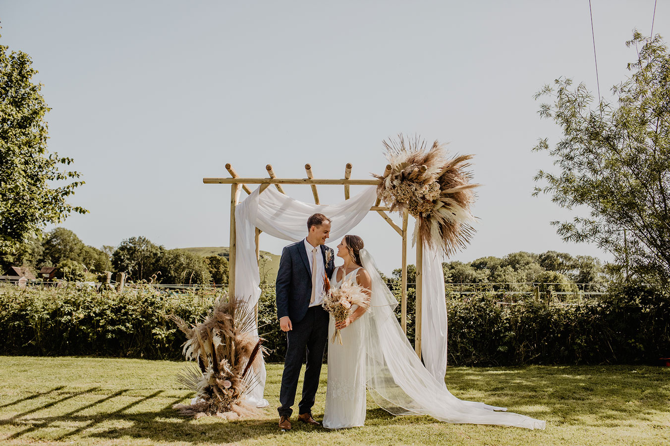 Bruidspaar naast een trouwboog
