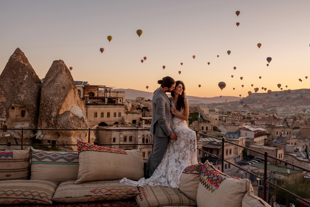 Bruidspaar met uitzicht op luchtballonnen in Cappadocië