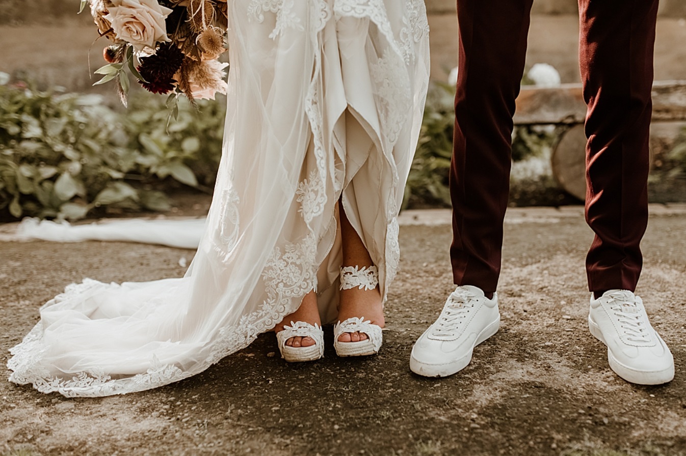 Bruidegom met witte sneakers onder rood trouwpak
