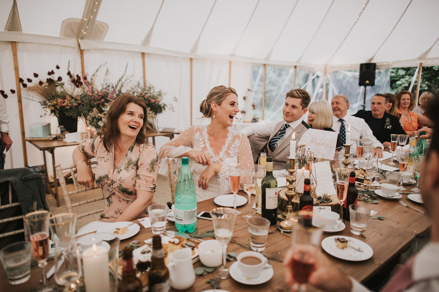 Bruidspaar aan tafel tijdens shared dining op hun bruiloft