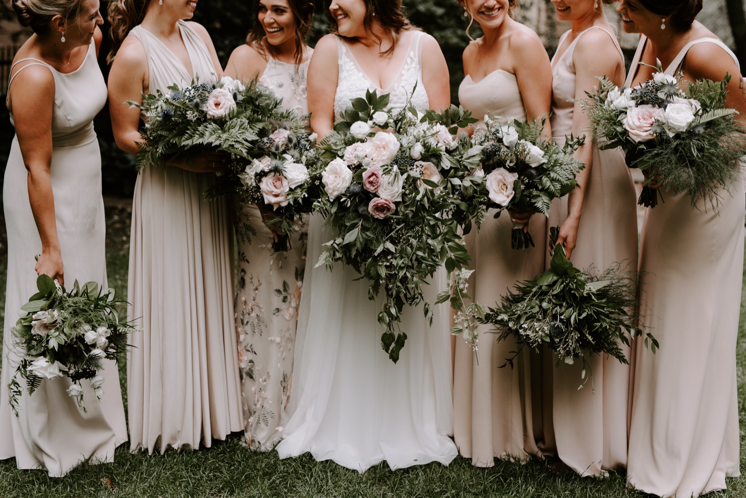 Bruid met haar bruidsmeisjes en bloemen in de handen
