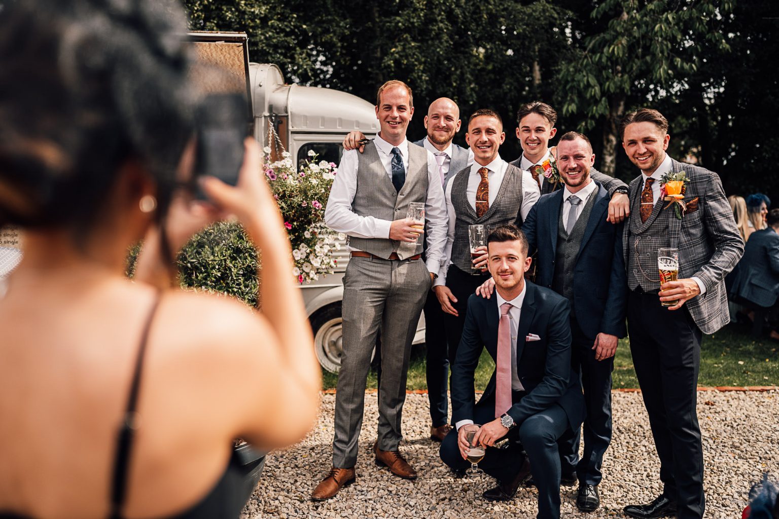 Vrouw zet mannen op de foto tijdens een bruiloft