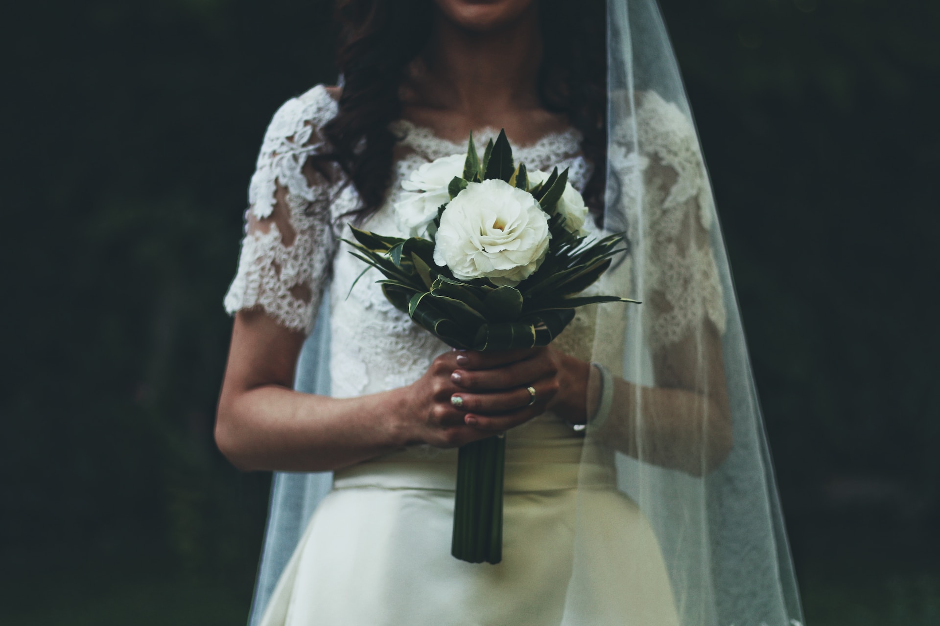 Bruid met simpel wit bruidsboeket in haar handen