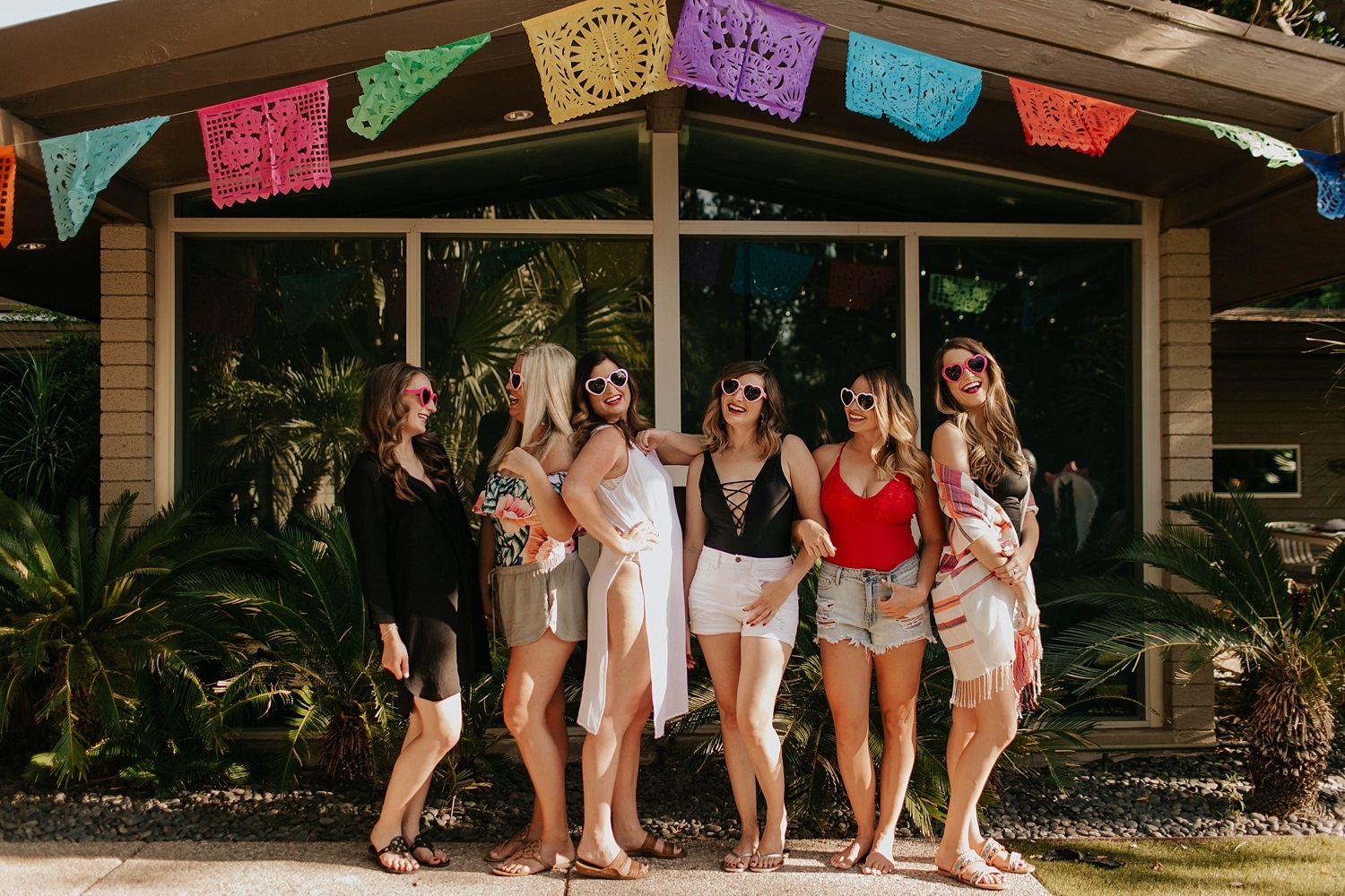 Kleine groep vrouwen met vlaggetjes boven hun hoofd op een bachelorette party